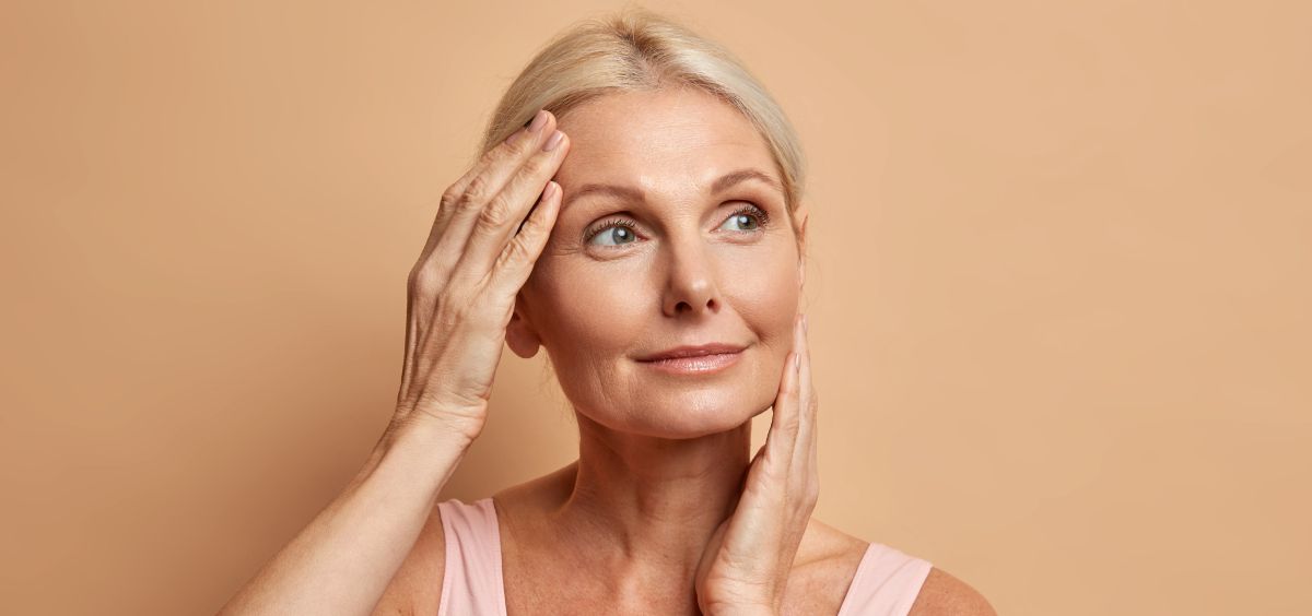 mujer-de-mediana-edad-tocandose-el-rostro-foto-freepik